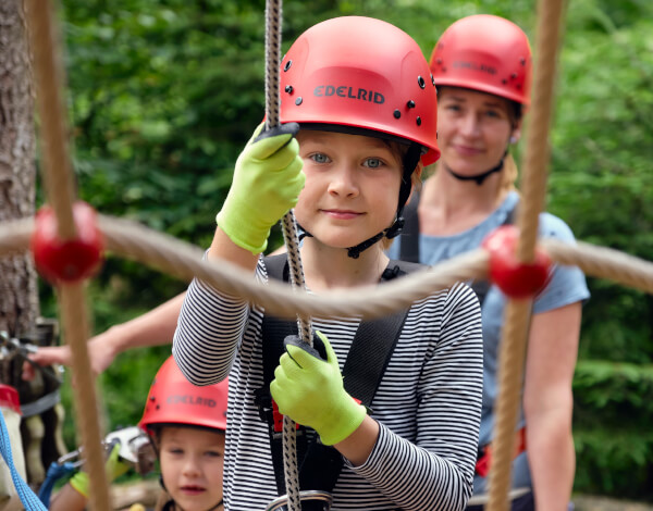 Drei Menschen klettern in einem Netz